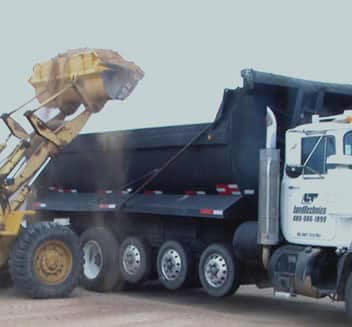 Front end loader dumping debris into dump truck, Land Technics, Mesa, AZ